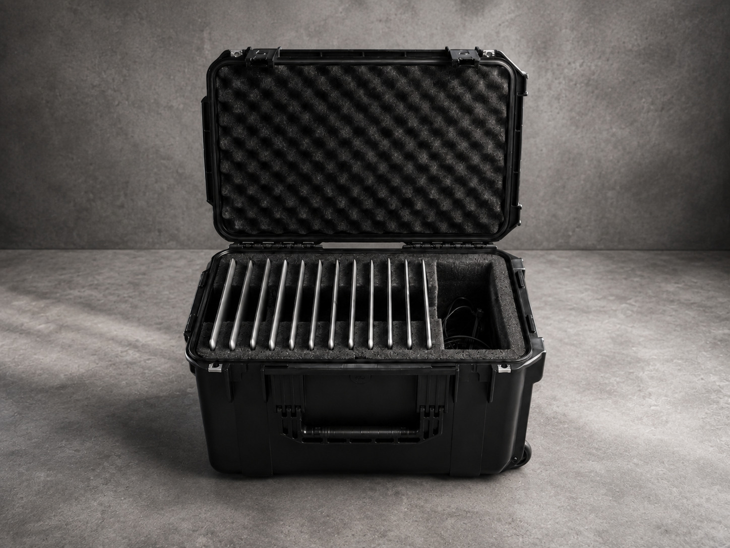 A wheeled protective case with a slotted foam insert holding a row of laptops