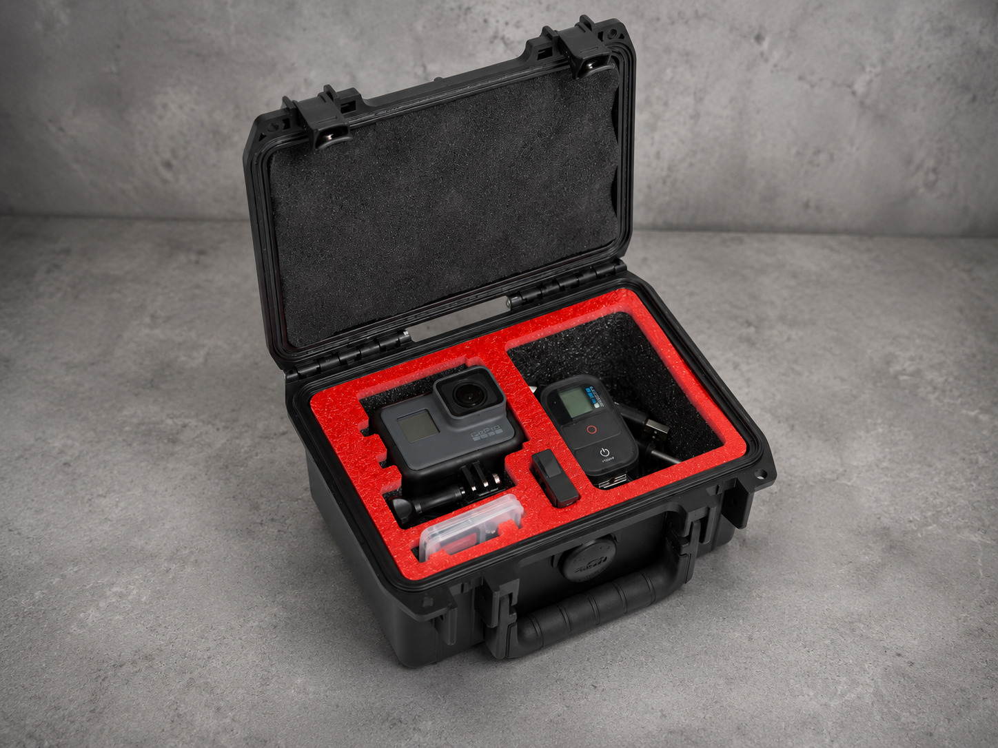 A protective case with a red foam insert holding a camera and its accessories