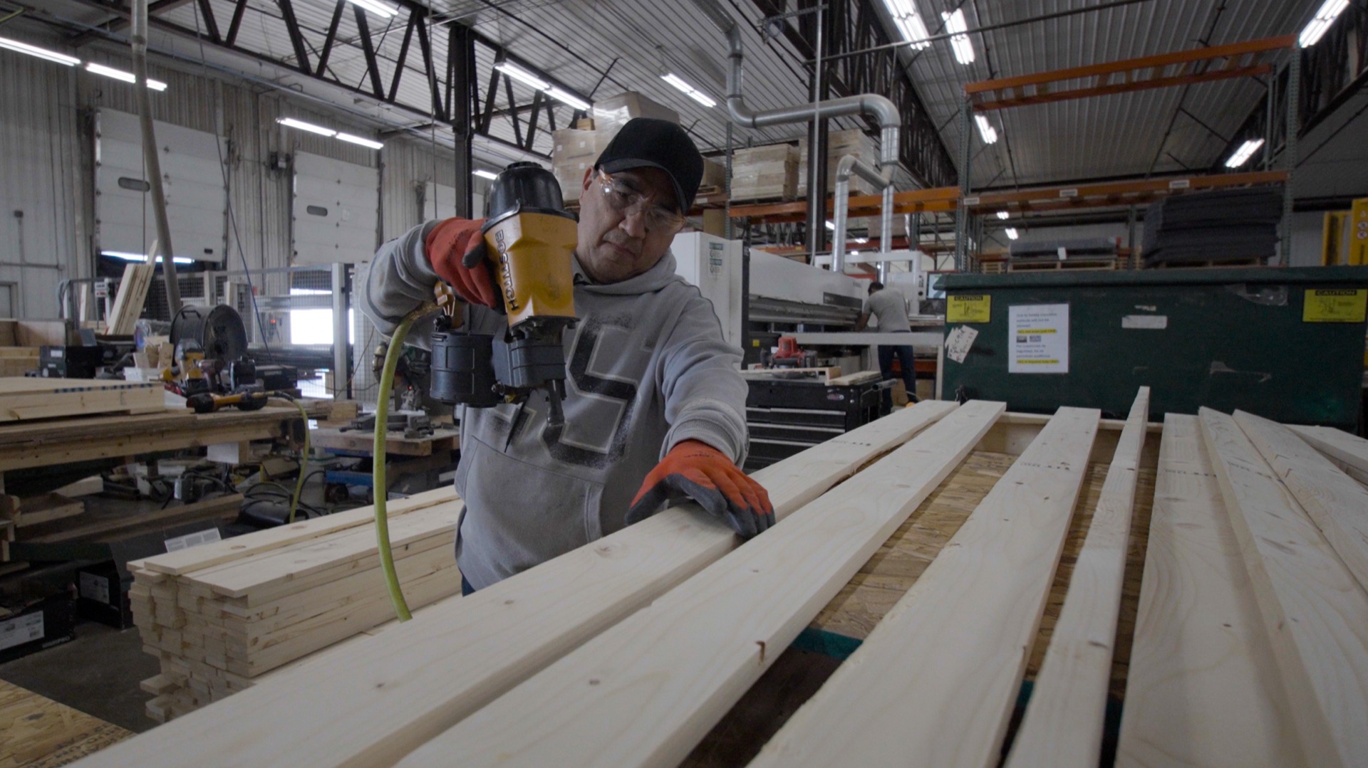 A FoamCraft craftsman assembling a wood crate with a pneumatic nailer